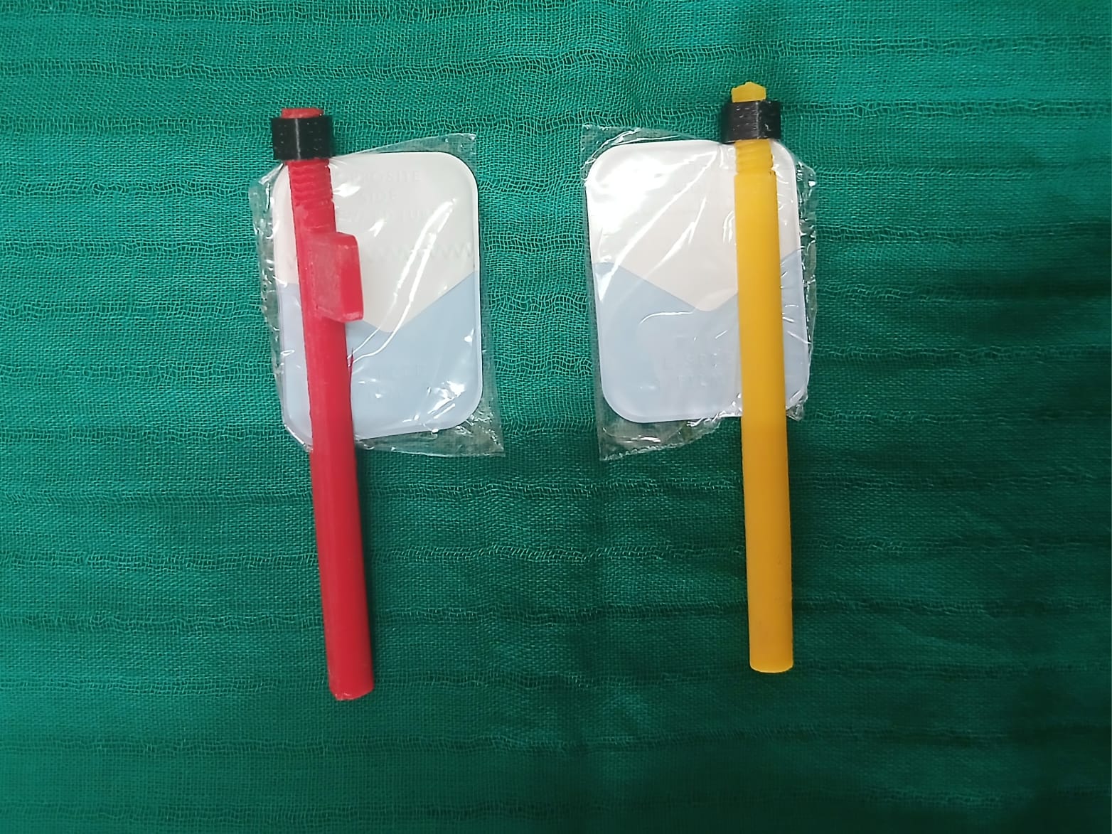 Two KARVI film holders — one red, one yellow — each holding an intraoral X-ray film packet.